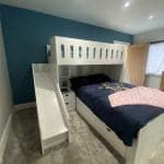 L-shaped double bed and single bed bunk with integrated shelves