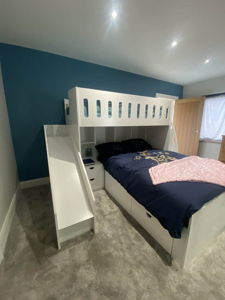 L-shaped double bed and single bed bunk with integrated shelves