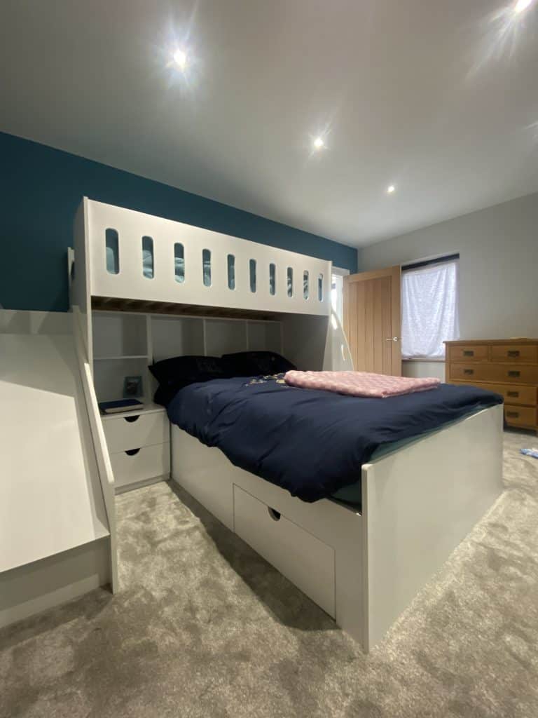 L-shaped bunk bed with double on bottom and single on top with storage compartments